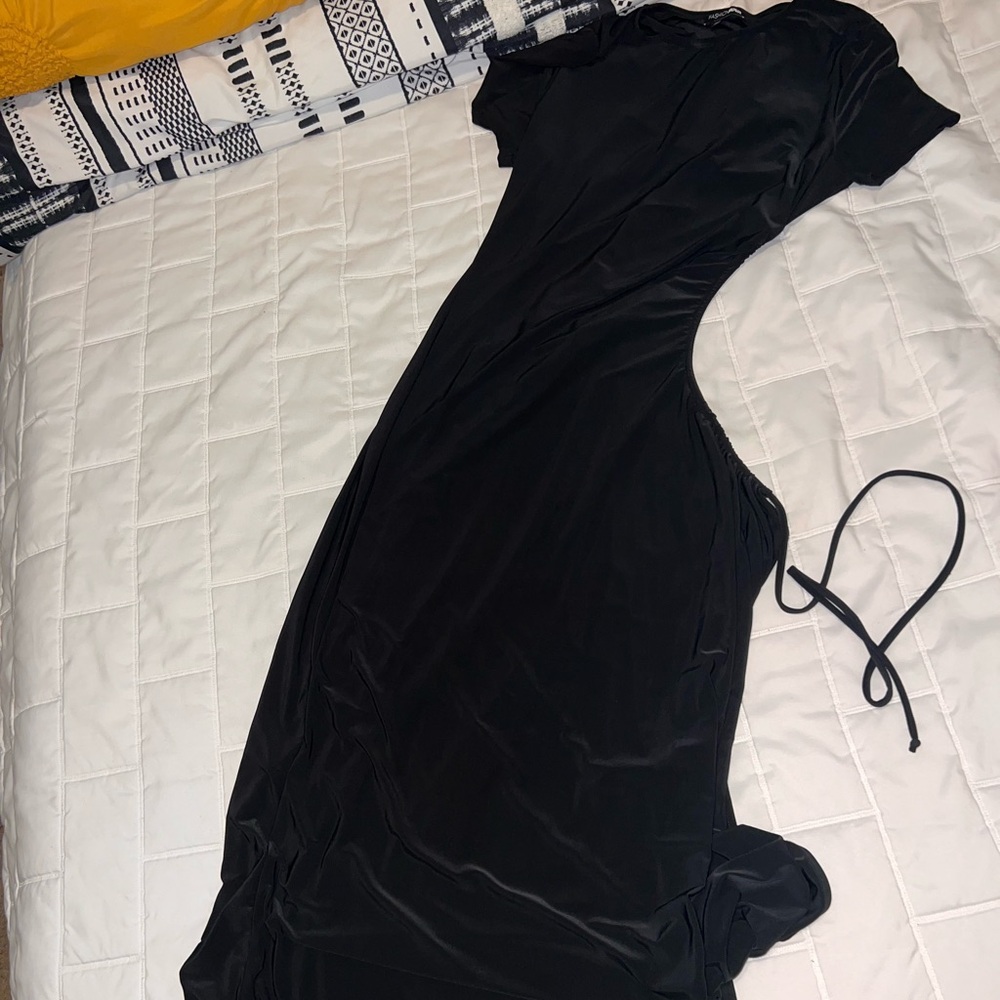 Very long black sundress with a whole split on one side .